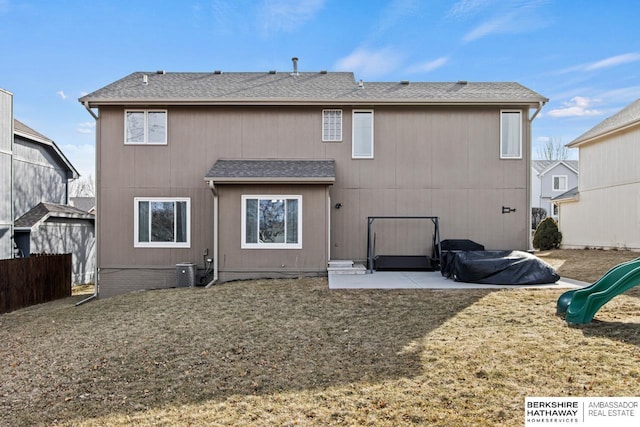 rear view of property with a playground, a yard, and a patio area