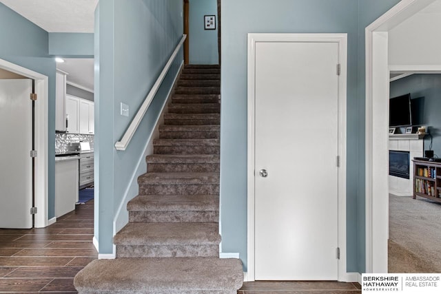 staircase featuring a tiled fireplace