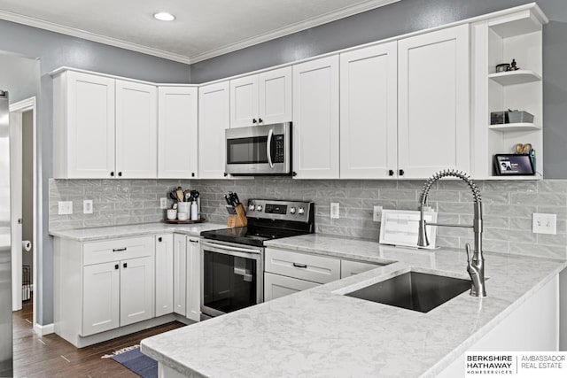 kitchen with stainless steel appliances, white cabinetry, and light stone countertops