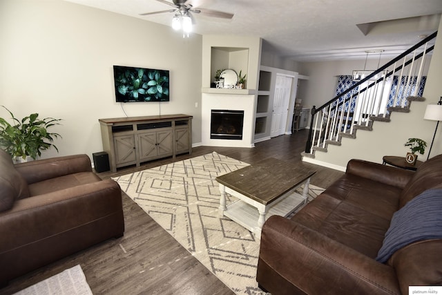 living room featuring dark wood-type flooring and ceiling fan