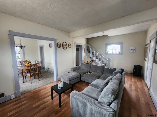 living room with dark wood-type flooring and a notable chandelier