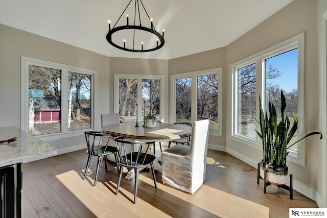 dining area with an inviting chandelier, plenty of natural light, beverage cooler, and light hardwood / wood-style flooring