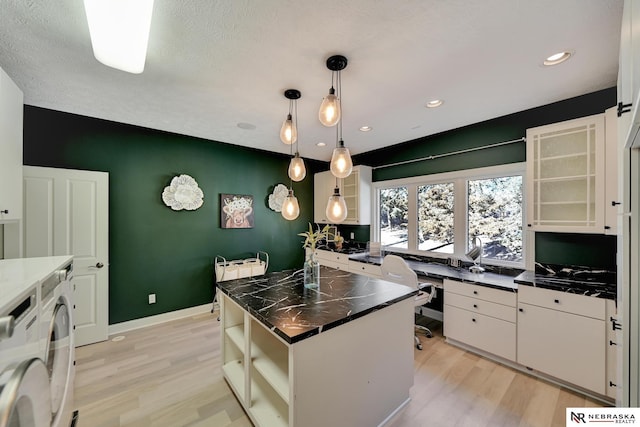 kitchen with pendant lighting, light hardwood / wood-style floors, a kitchen island, and white cabinets