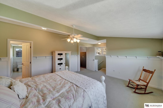 bedroom featuring ceiling fan, lofted ceiling, light carpet, and a textured ceiling