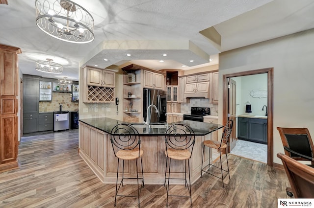 kitchen with a breakfast bar, stainless steel refrigerator, decorative light fixtures, black electric range oven, and dark wood-type flooring