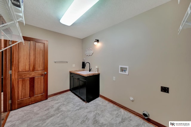 laundry room with hookup for a gas dryer, hookup for a washing machine, sink, and a textured ceiling