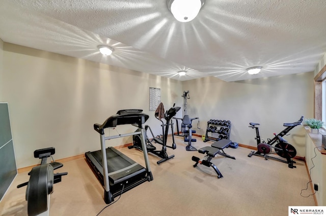 exercise room featuring carpet floors and a textured ceiling