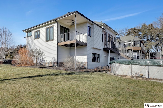 back of property with a yard and ceiling fan