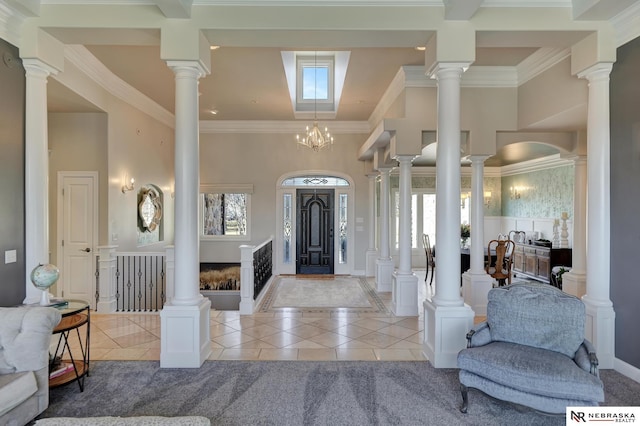 entryway with ornamental molding, plenty of natural light, light tile patterned floors, and ornate columns