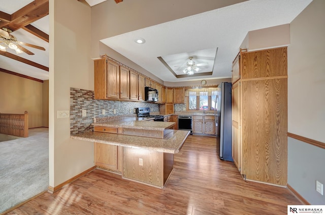 kitchen with a breakfast bar area, tasteful backsplash, kitchen peninsula, ceiling fan, and black appliances