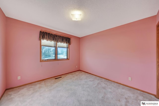 spare room with carpet floors and a textured ceiling