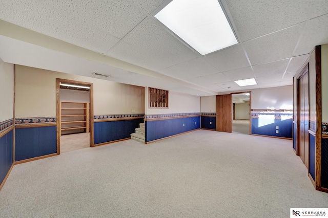 basement featuring carpet flooring and a paneled ceiling