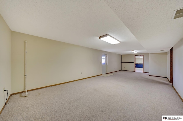 empty room with light carpet and a textured ceiling