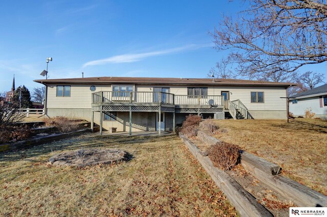 rear view of property featuring a deck and a lawn