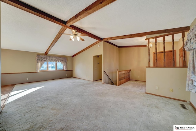 unfurnished living room featuring light carpet, ceiling fan, lofted ceiling with beams, and a textured ceiling