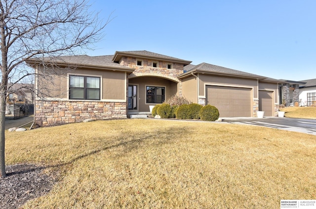 prairie-style house featuring a garage and a front lawn