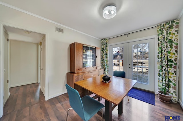 dining area with crown molding, dark hardwood / wood-style floors, and french doors