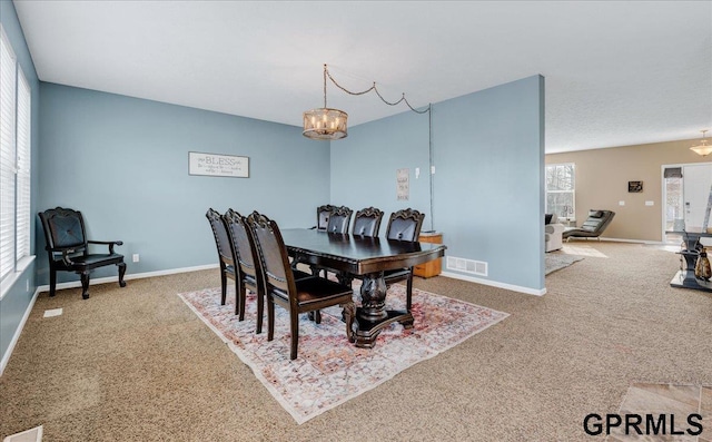 dining area featuring a chandelier and carpet floors