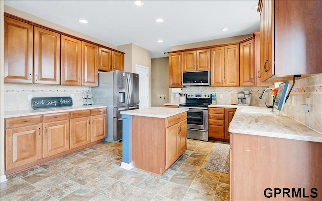 kitchen featuring sink, light stone counters, appliances with stainless steel finishes, a kitchen island, and decorative backsplash