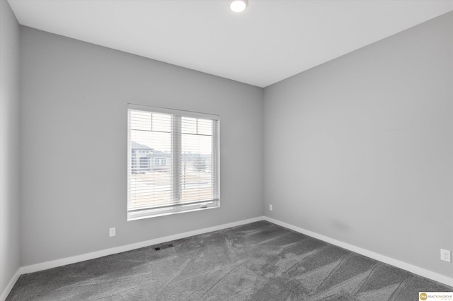 empty room featuring dark colored carpet