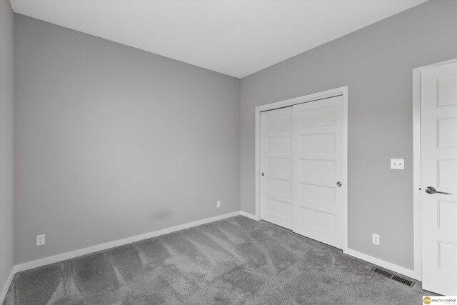 unfurnished bedroom with carpet floors and a closet