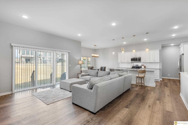 living room with hardwood / wood-style floors and a notable chandelier