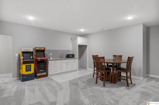 dining room featuring sink and light carpet