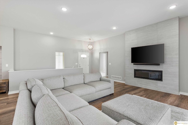 living room with dark hardwood / wood-style flooring and a large fireplace