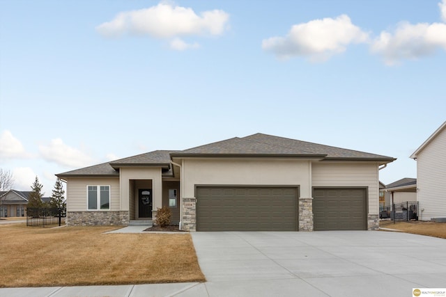 prairie-style home with a garage and a front lawn