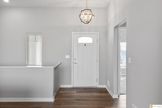 foyer entrance with a notable chandelier and dark hardwood / wood-style flooring