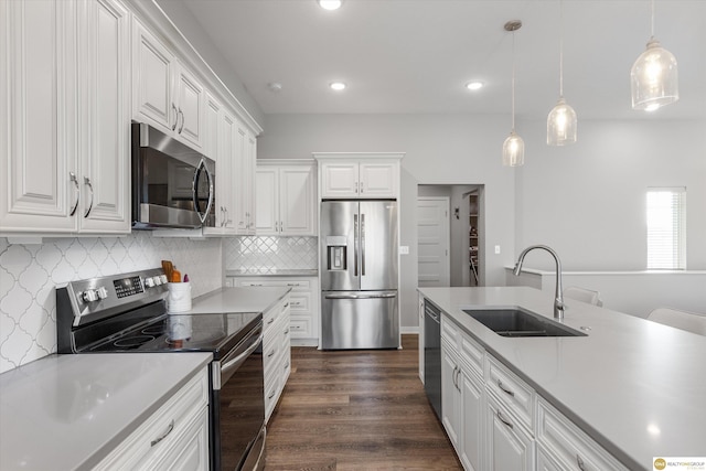 kitchen featuring white cabinetry, stainless steel appliances, sink, and pendant lighting