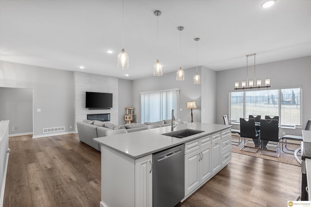 kitchen featuring sink, white cabinetry, hanging light fixtures, a center island with sink, and stainless steel dishwasher