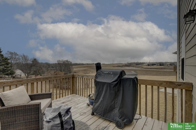 wooden deck with a rural view and a grill