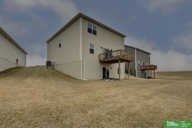 back of property with central AC, a deck, and a lawn