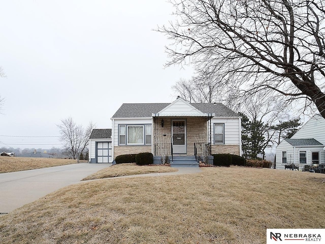 bungalow-style home with a garage and a front lawn