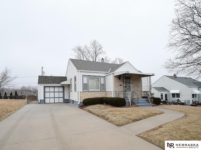 view of front facade with a garage, an outbuilding, and a front lawn