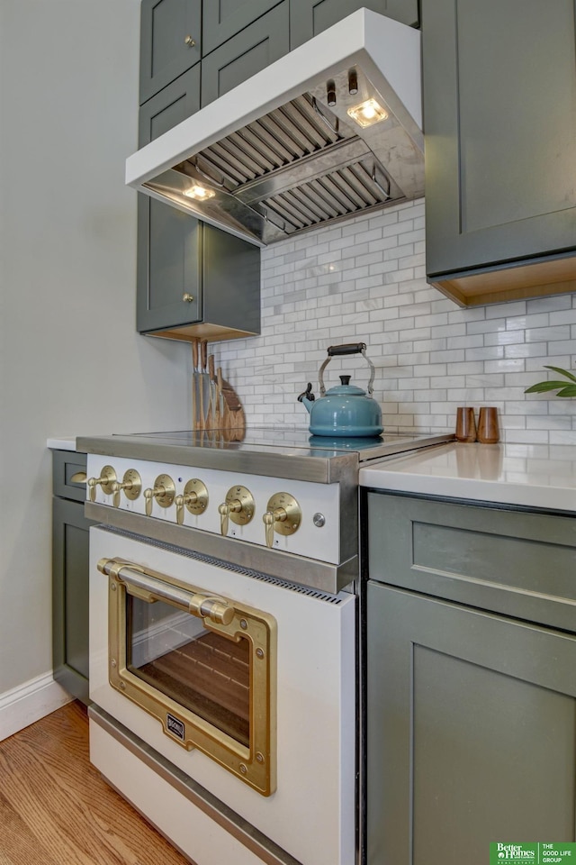 kitchen featuring tasteful backsplash, exhaust hood, and light hardwood / wood-style floors