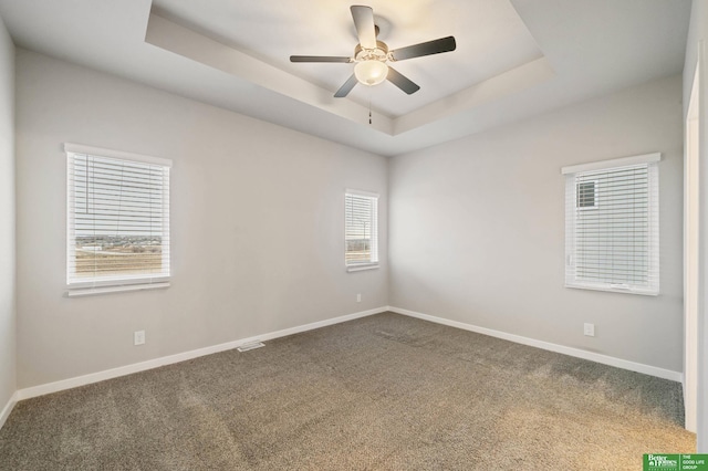 unfurnished room featuring carpet, ceiling fan, and a tray ceiling