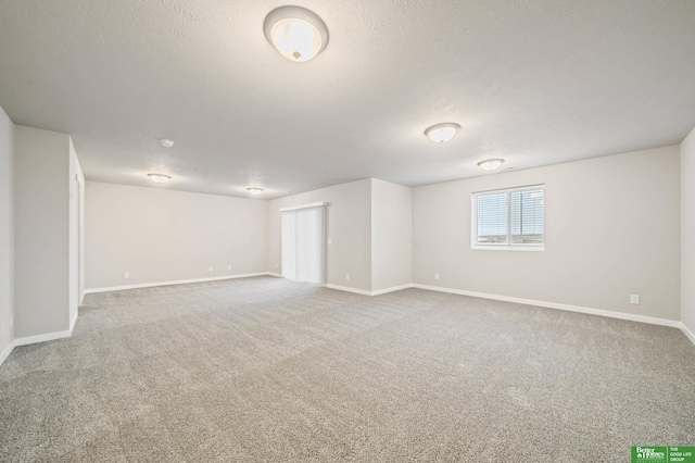 spare room featuring a textured ceiling and carpet