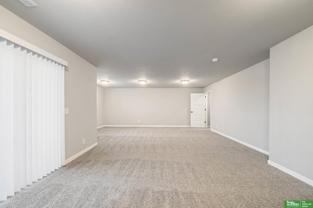 carpeted empty room featuring a textured ceiling