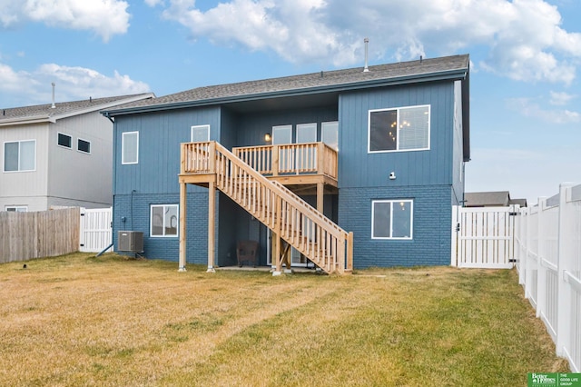 rear view of property featuring a wooden deck, a yard, and central air condition unit