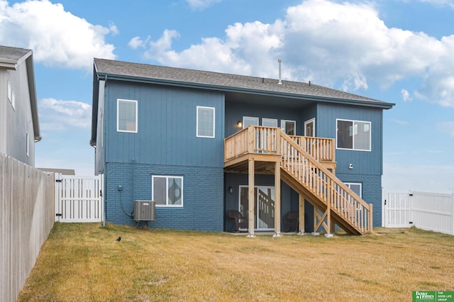 rear view of house with a wooden deck, a yard, and central AC unit