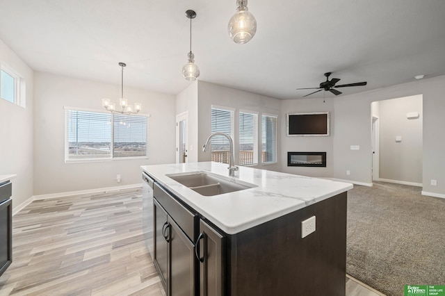 kitchen with pendant lighting, sink, plenty of natural light, an island with sink, and ceiling fan with notable chandelier