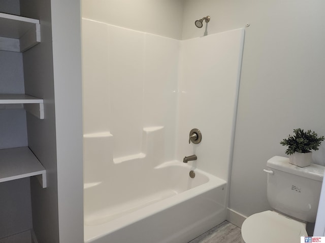 bathroom with shower / bathing tub combination, hardwood / wood-style floors, and toilet