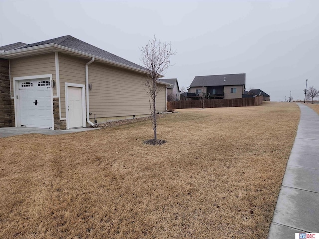 view of property exterior featuring a garage and a lawn