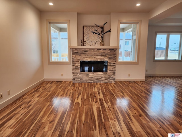 unfurnished living room with plenty of natural light, hardwood / wood-style floors, and a fireplace