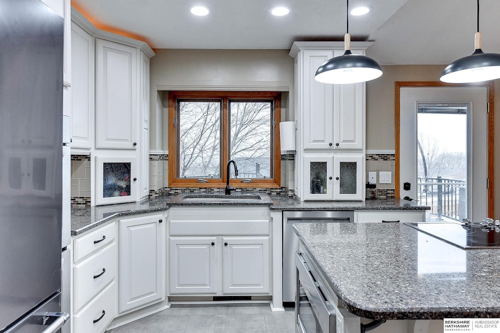 kitchen featuring pendant lighting, sink, and white cabinets