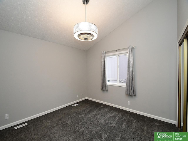 carpeted empty room featuring lofted ceiling and a textured ceiling