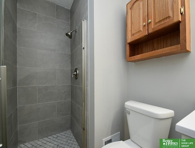 bathroom featuring a tile shower and toilet