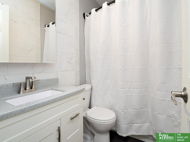 bathroom featuring tasteful backsplash, vanity, tile walls, and toilet